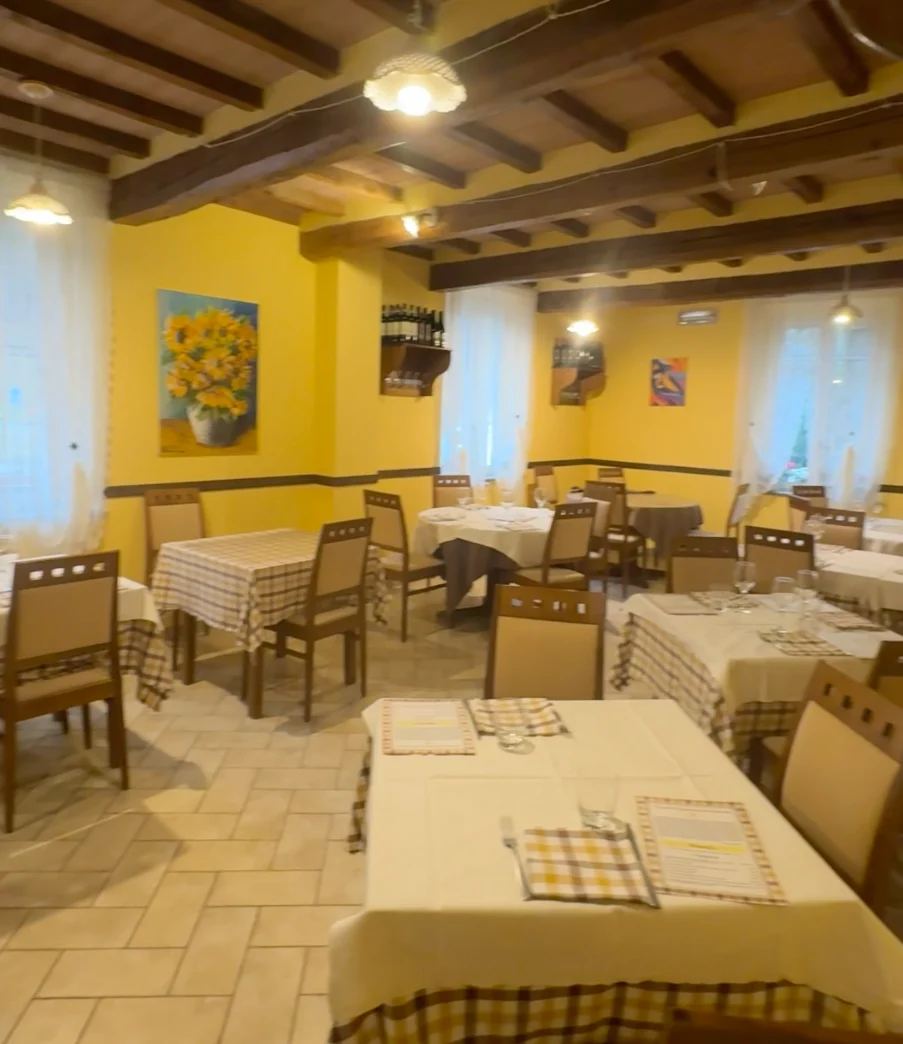 Sala gialla con tavoli apparecchiati